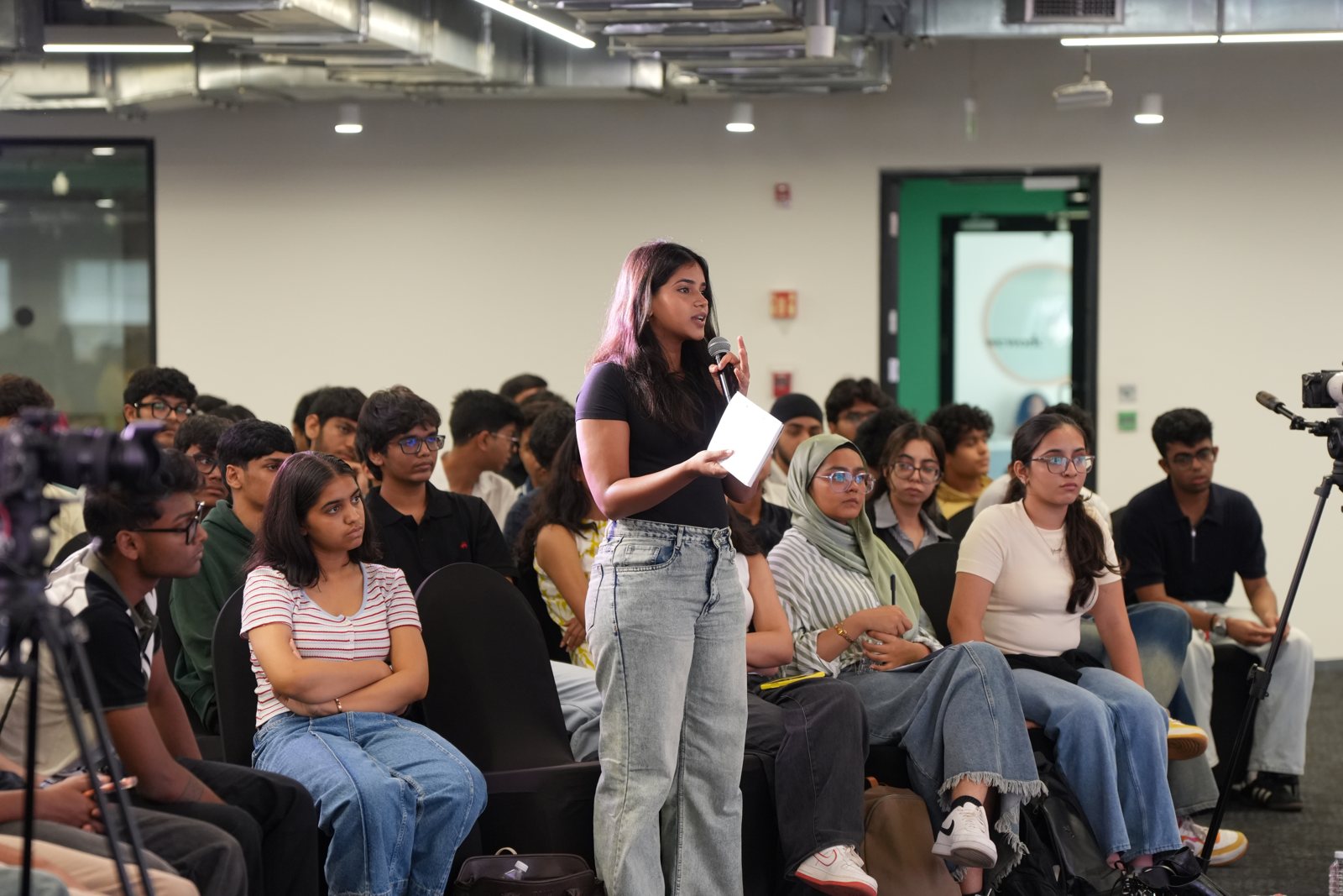 A student asking a question with a microphone in a full Mesa session
