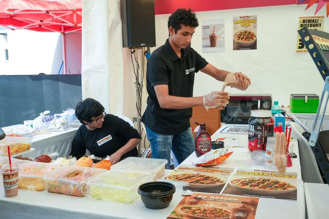 A student preparing food orders at a stall