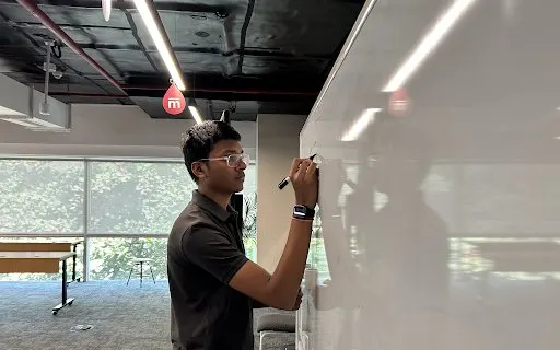A student mapping out a product architecture on a whiteboard