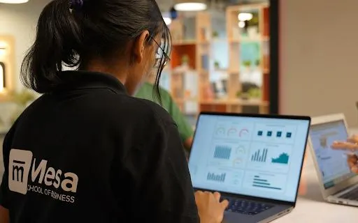 A student building a dashboard prototype on her laptop