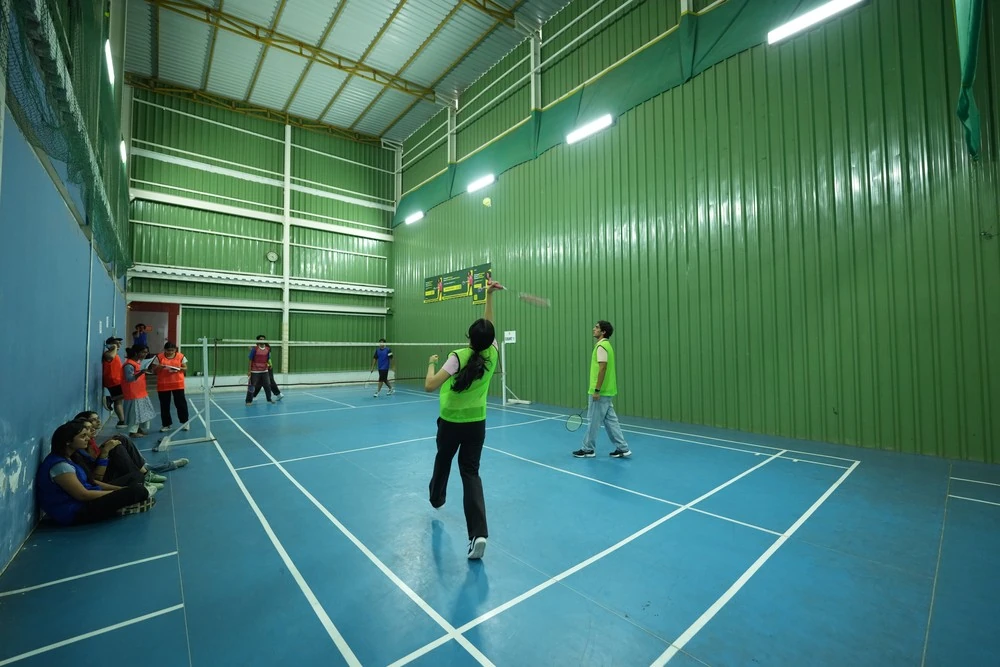 Students playing badminton on an indoor court