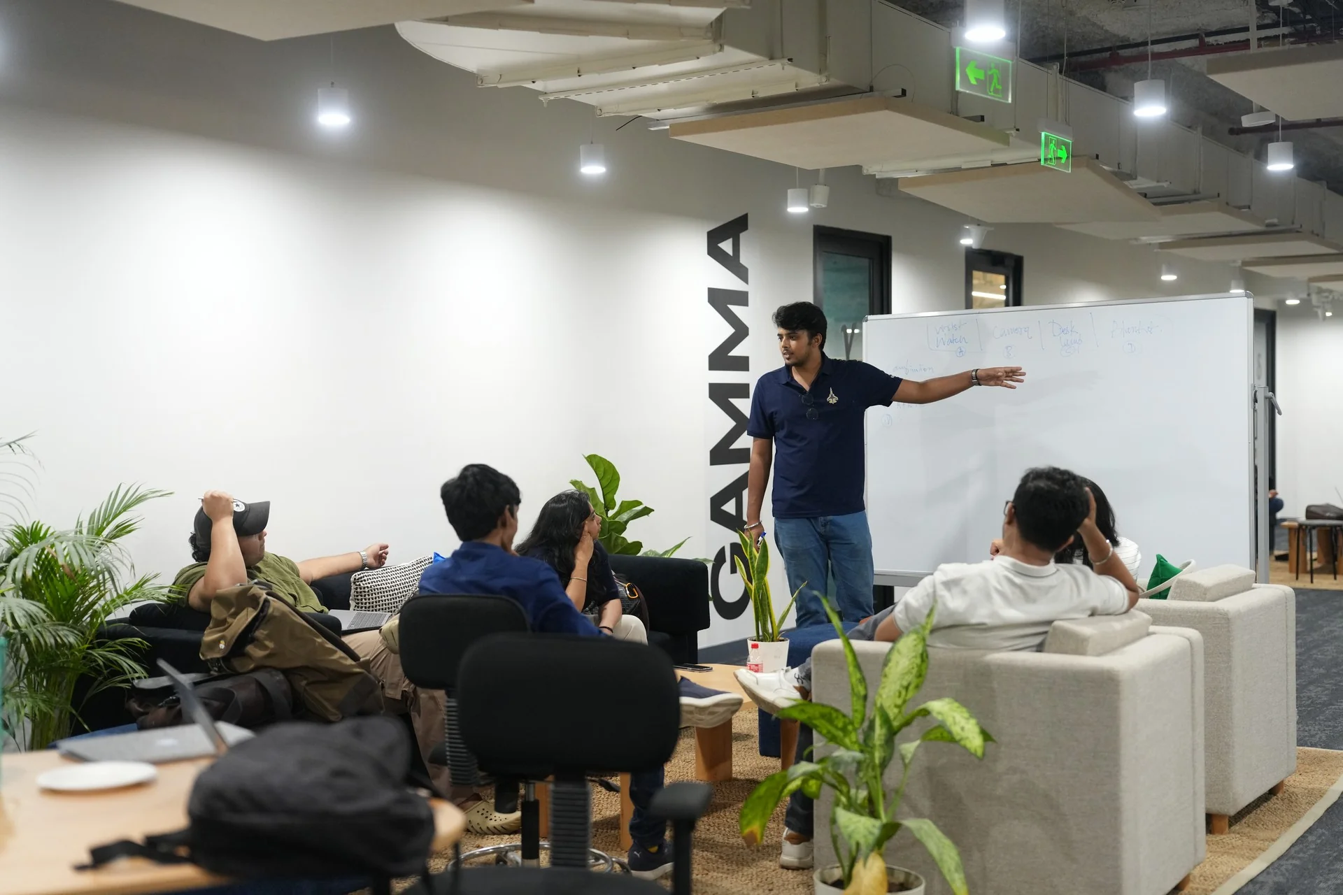 A student presenting at a whiteboard to classmates in the lounge