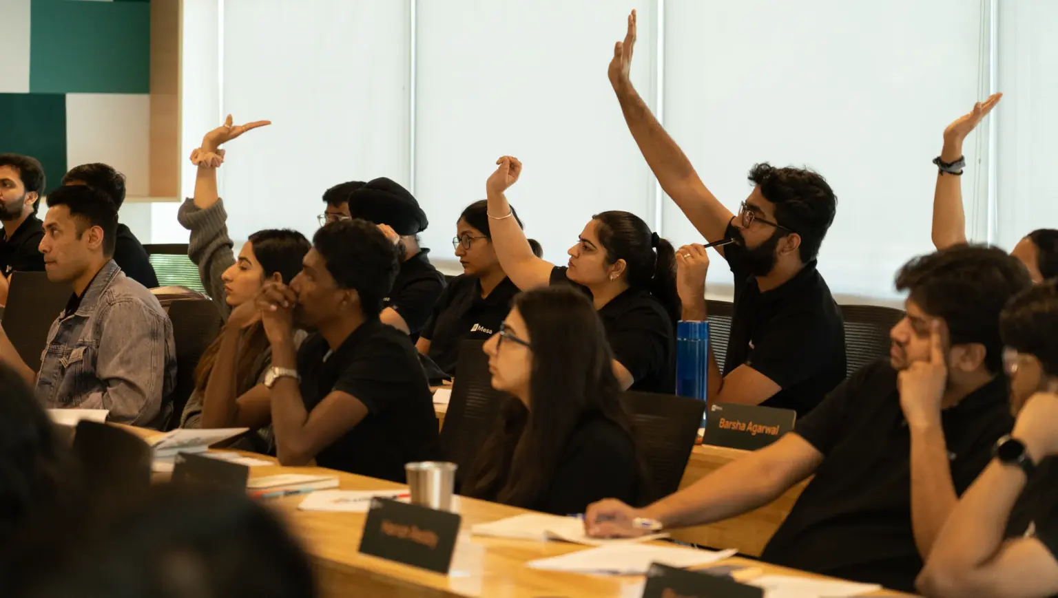 Mesa School undergraduate students raising their hands during a class discussion