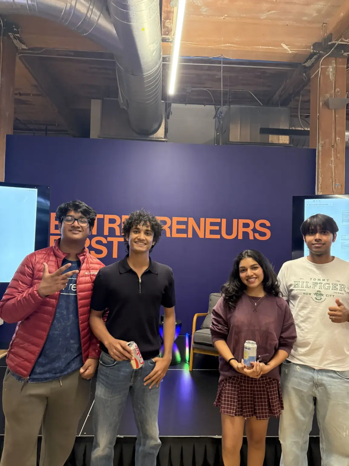 Mesa School undergraduate students in front of the Entrepreneur First wall inside its San Francisco office