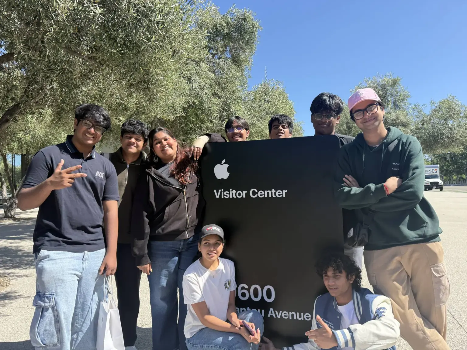 Mesa School undergraduate students gathered around the Apple Visitor Center sign